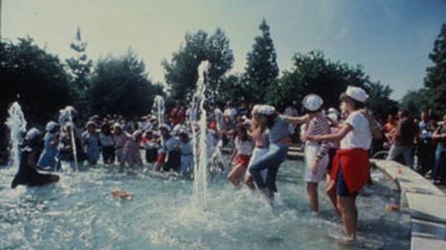 people dancing in a fountain